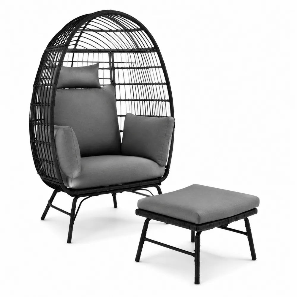 Sedia in rattan con cuscini grigi e poggiapiedi